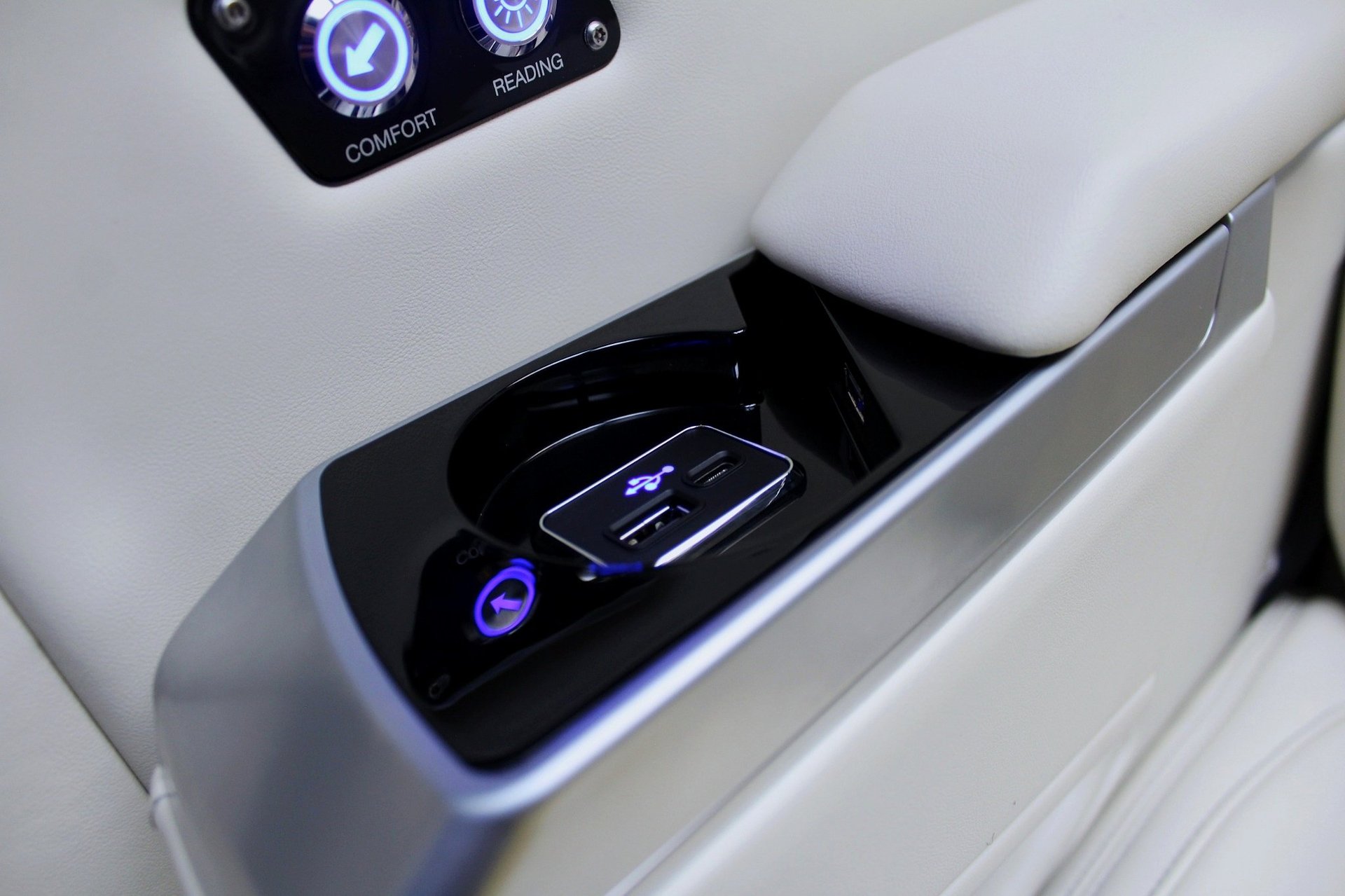 Car door panel with illuminated wireless charging pad and digital controls