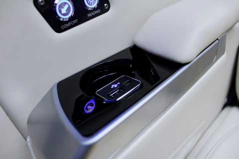 Car door panel with illuminated wireless charging pad and digital controls