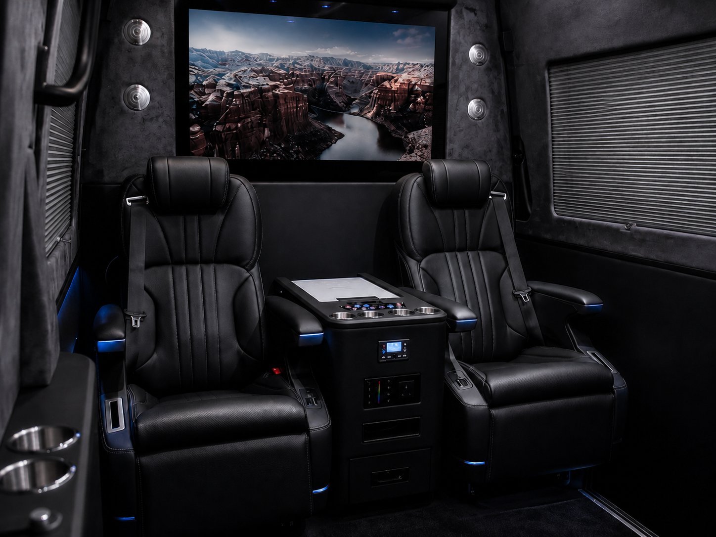 Luxury home theater room with two black leather recliners facing a large screen displaying a scenic mountain landscape