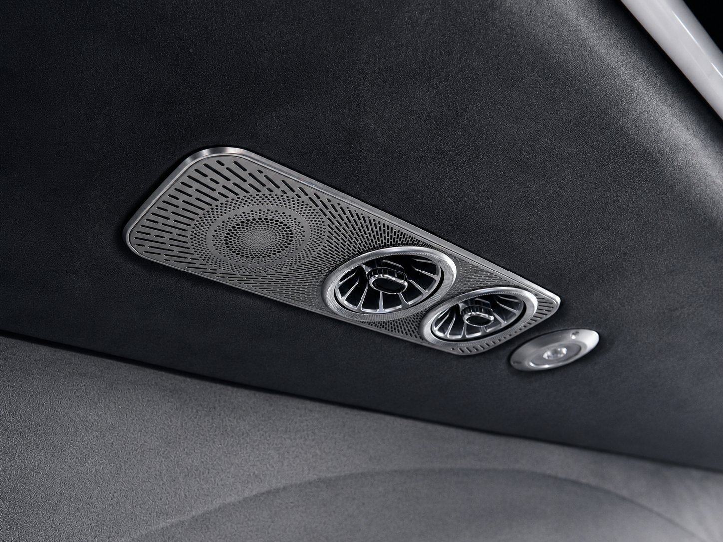 Car interior ceiling with ventilation grilles and round air vents mounted on black headliner