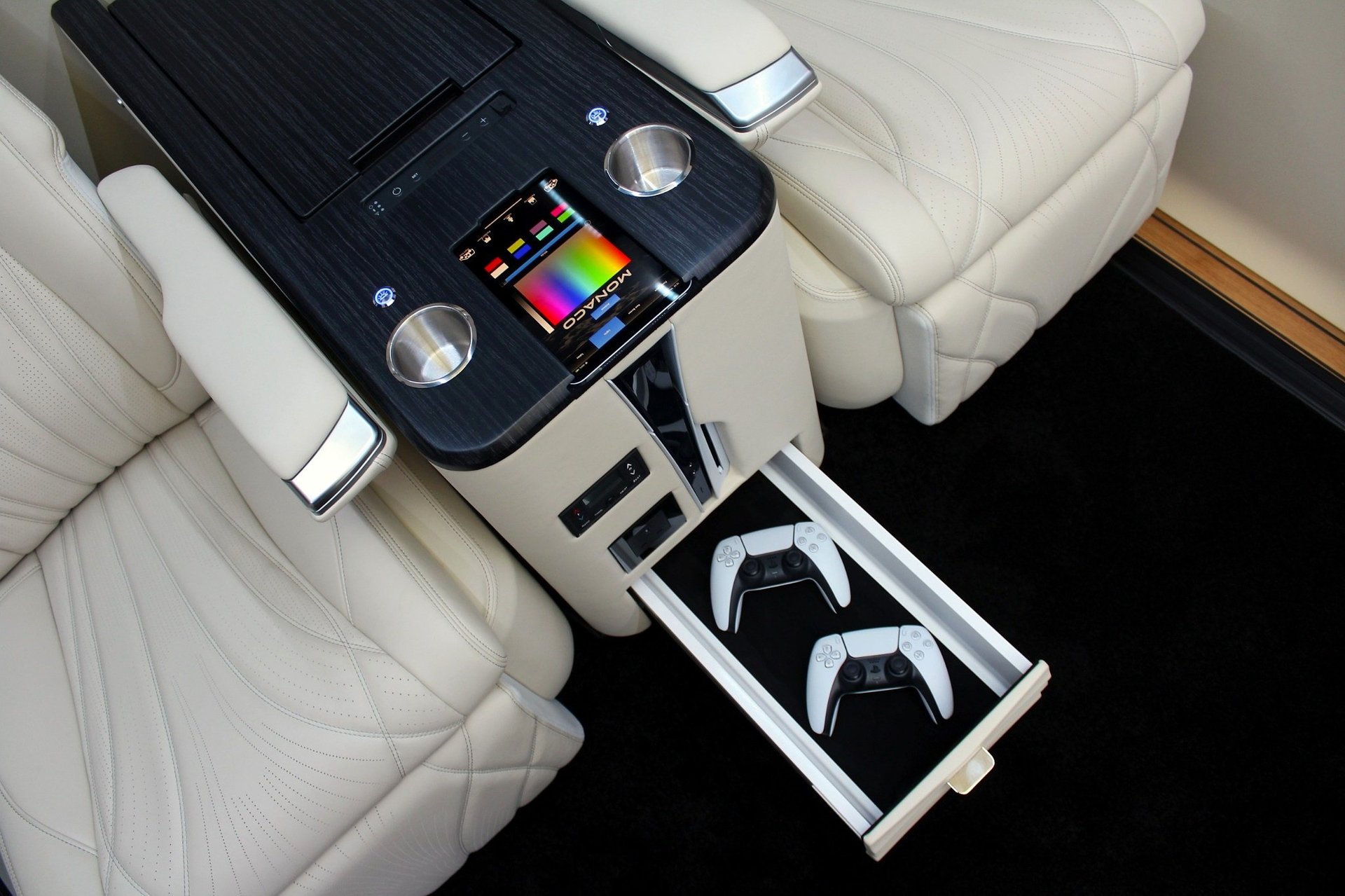 Overhead view of a luxury car console with solar panel roof, colorful display screen, and gaming controllers in white leather interior