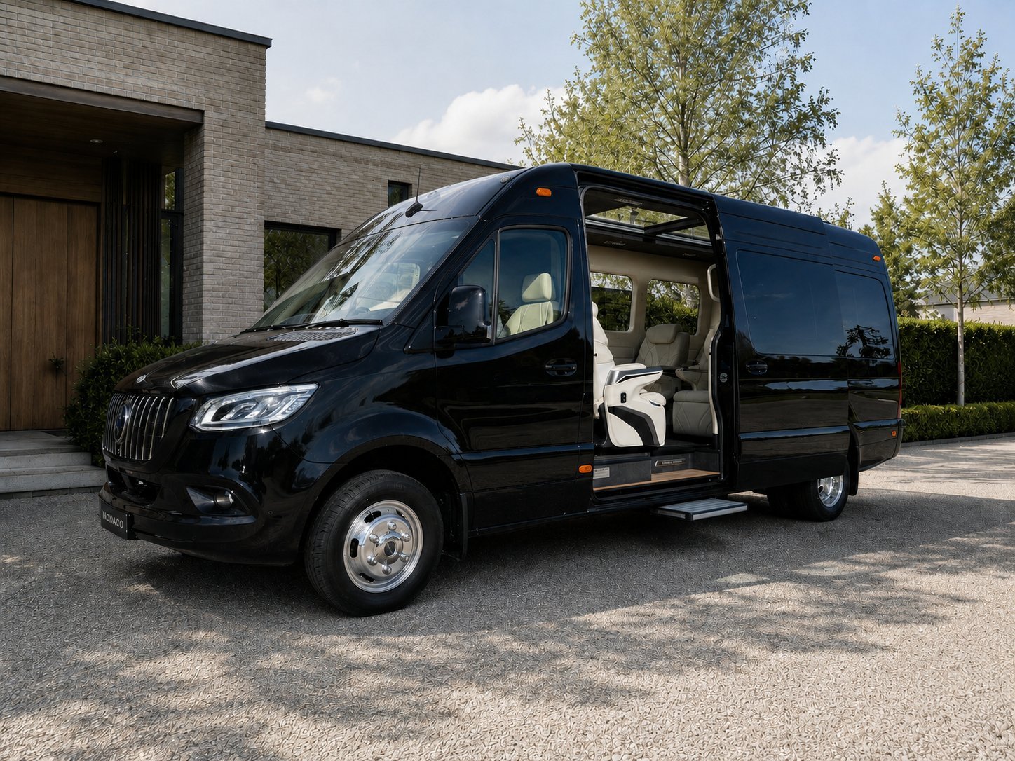 Black luxury minivan with open sliding door parked in front of modern house with trees