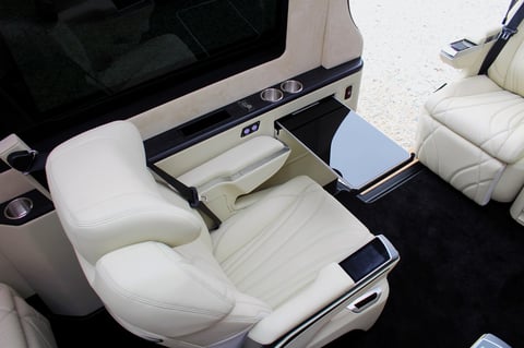 Overhead view of luxury boat cabin interior with white leather seating and storage compartments